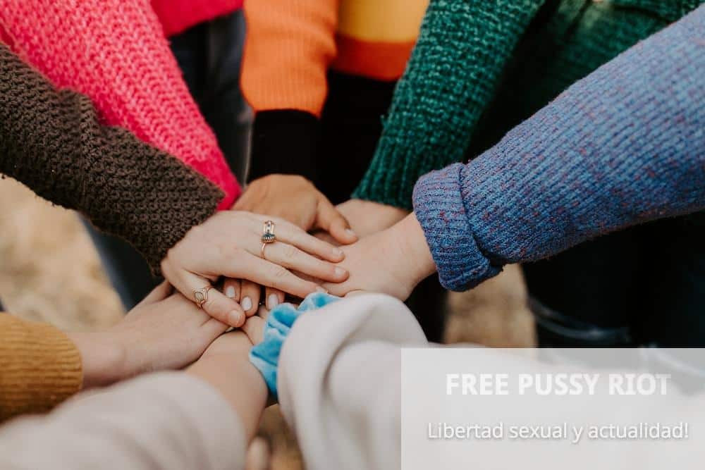 person in red sweater holding babys hand