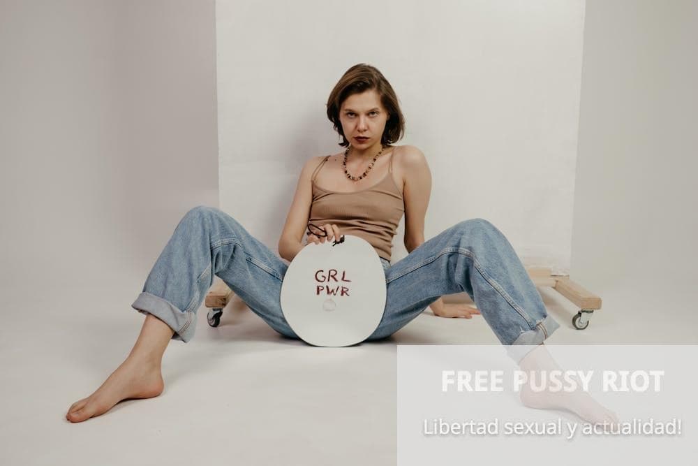 Confident young woman sitting with spread legs and showing banner with Grl Pwr inscription