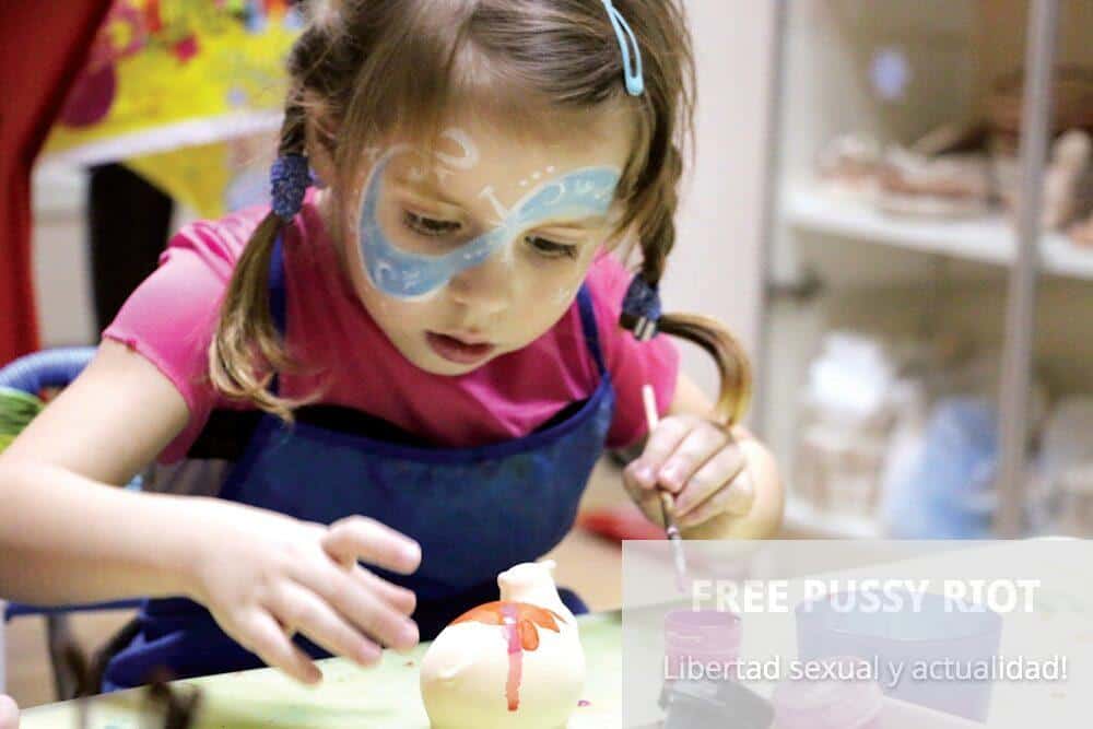 girl in blue and red long sleeve shirt holding white and pink plastic toy
